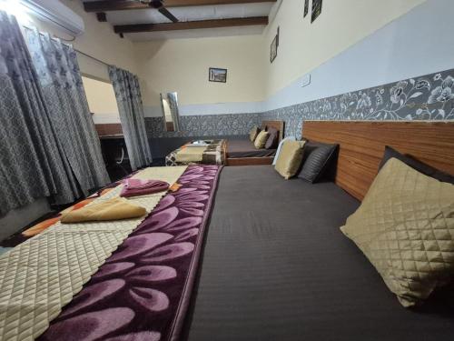 a room with three beds and a couch at The Street Homestay-600m from Taj Mahal in Agra