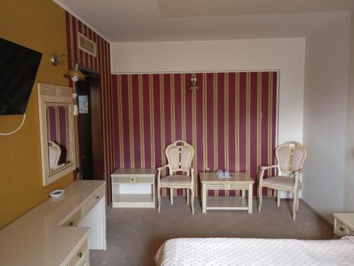 1 Schlafzimmer mit 2 Stühlen, einem Tisch und einem Bett in der Unterkunft Hotel Majestic City Center in Iaşi