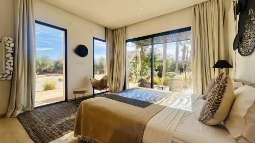a bedroom with a large bed and a large window at Villa Sbaa Marrakech in Marrakesh