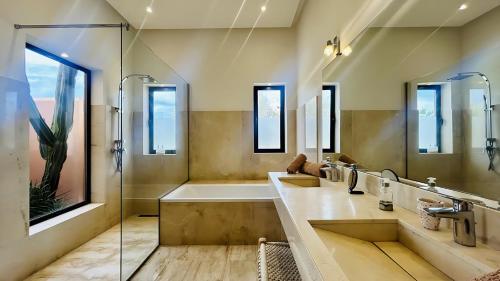 a bathroom with two sinks and a tub and a shower at Villa Sbaa Marrakech in Marrakesh