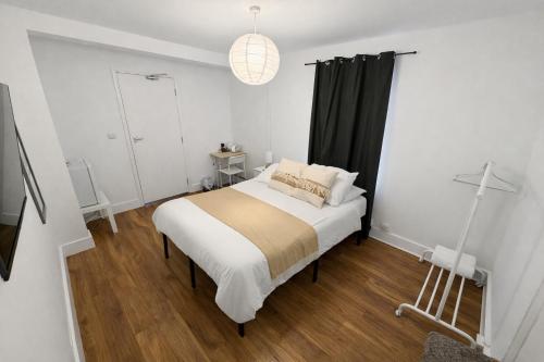 - une chambre avec un lit et un rideau noir dans l'établissement 43 Deluxe London Ensuites, à Londres