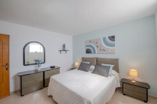 a white bedroom with a bed and a mirror at La Dimora del Bacchiss in Amalfi