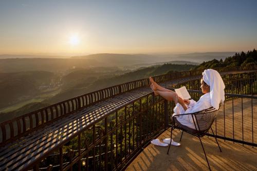 a woman sitting in a chair reading a book on a mountain at UTO KULM - Top of Zurich in Zurich
