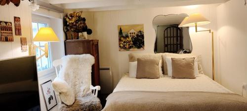 een slaapkamer met een bed en twee witte stoelen bij PARIS AUTHENTIC HOUSE Métro Line 14 Station Hôpital Bicêtre, RER B Gentilly in Parijs