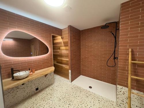 een badkamer met een bad, een wastafel en een spiegel bij Le lofty in Stoumont