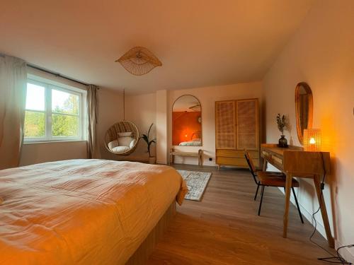 een slaapkamer met een bed, een bureau en een tafel bij Le lofty in Stoumont