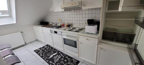 een keuken met witte kasten en een zwart-wit tapijt bij Kahler Pőn in Willingen