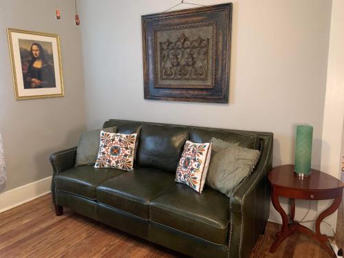 a black leather couch in a living room with a table at Cozy Home close to Downtown in San Antonio