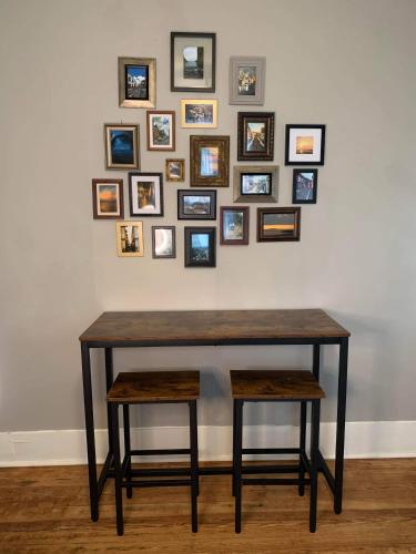 a table with two stools in front of a wall with pictures at Cozy Home close to Downtown in San Antonio