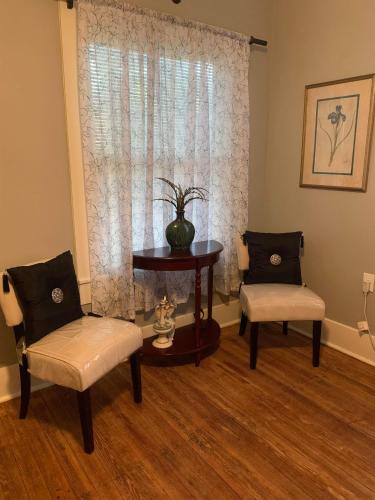 a living room with two chairs and a table and a window at Cozy Home close to Downtown in San Antonio