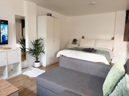 ein Schlafzimmer mit einem Bett, einer Couch und einem Fernseher in der Unterkunft Perfect Family Home Enfield in Enfield