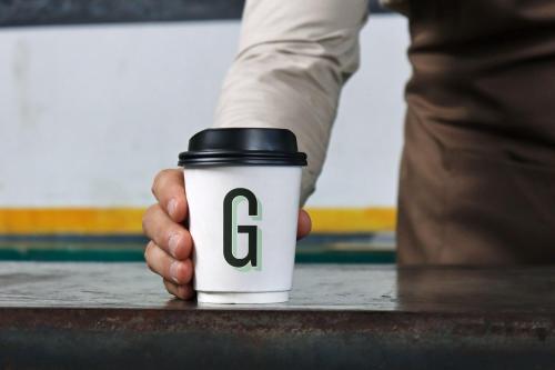 a hand holding a coffee cup with the g on it at Garner Hotel Lincoln by IHG in Lincoln