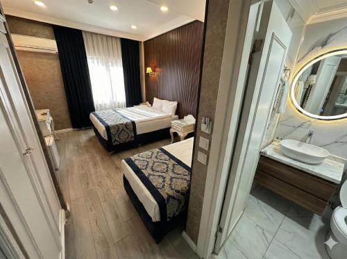a hotel room with two beds and a sink at B Corner Hotel Bistro in Istanbul