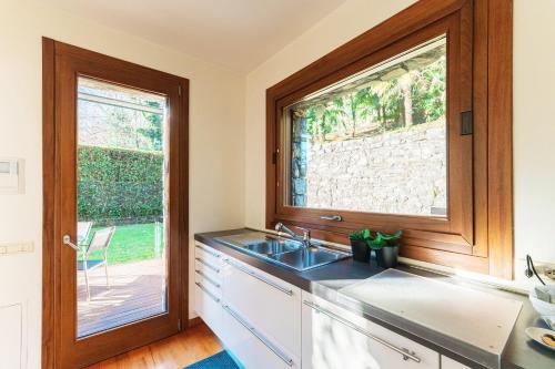 une cuisine avec un évier et une fenêtre dans l'établissement Villa Mara - by MyHomeInComo, à Côme