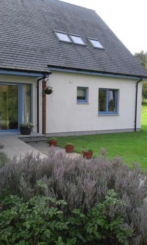 a house with windows and plants in front of it at Suardal Guest House in Fort Augustus