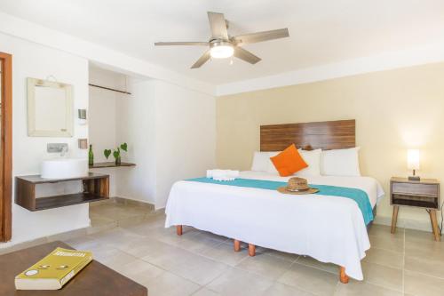a bedroom with a large bed with a ceiling fan at La Diosa Kali Beach Front Hotel in Holbox Island