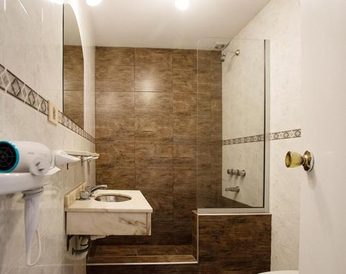 een badkamer met een wastafel en een douche bij Alamos Hosteria in Mar Azul