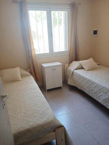 a bedroom with two beds and a window at Cómoda y tranquila in General Alvear
