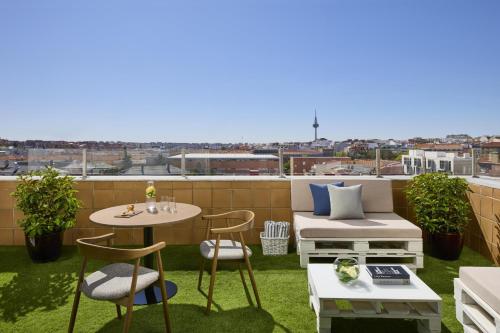 eine Terrasse mit einem Tisch und Stühlen auf dem Dach in der Unterkunft NH Madrid Ventas in Madrid