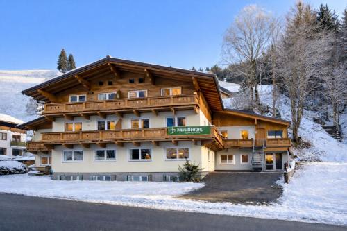 ein Gebäude im Schnee mit einem Schild drauf in der Unterkunft Haus Dienten Appartements am Hochkoenig in Dienten am Hochkönig