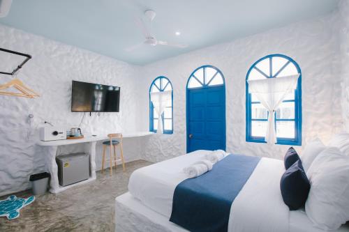 a bedroom with a bed with a blue door and windows at Sweett Lemon Home in Patong Beach