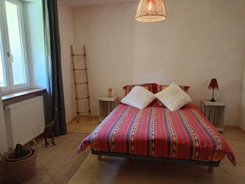 a bedroom with a bed with two pillows on it at la maison de la Felicidad in Boussy