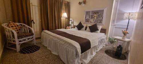 a bedroom with a large bed and a chair at The Moonvale Cottage A Victorian Theme Independent Homestay! in Chandīgarh
