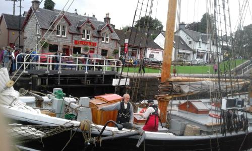 a man standing on a boat in a harbor at Suardal Guest House in Fort Augustus