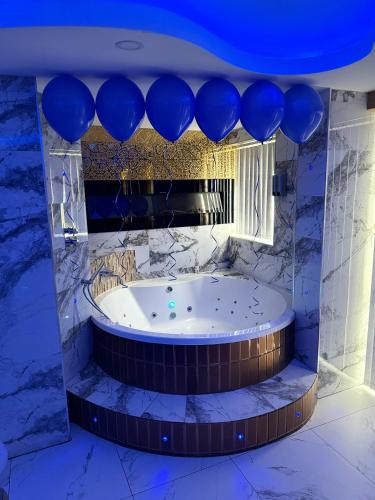 a jacuzzi tub in a room with blue balloons at Luxury Suites in Bradford