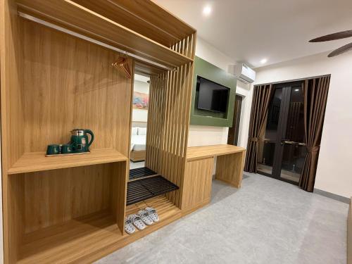 um quarto com uma televisão e uma parede de madeira em Bacnam Quang Ngai Hotel em Kon Rung (1)