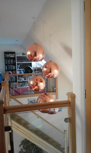 a group of copper lights hanging from a staircase at Suardal Guest House in Fort Augustus