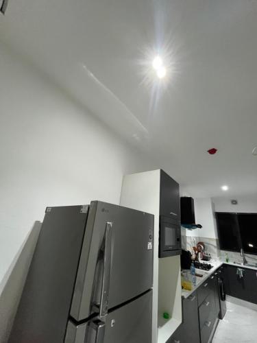 a kitchen with a refrigerator and a light on the ceiling at Apex apartment in Ilado