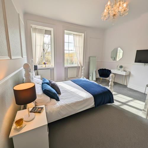 a bedroom with a bed and a desk with a lamp at Manor Park Country House in Swansea