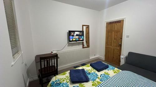 a bedroom with a bed and a flat screen tv at Greenwich Homestay in London