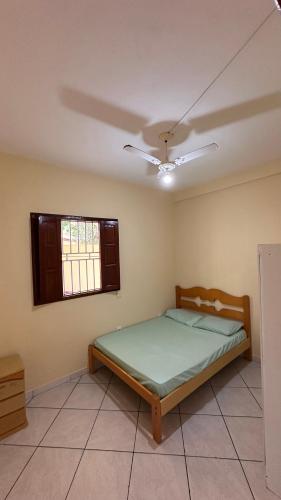 een slaapkamer met een bed en een plafondventilator bij Casa Guriri in São Mateus