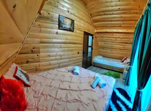 a bedroom with a bed in a wooden cabin at Cabana MARA in Poiana Vadului