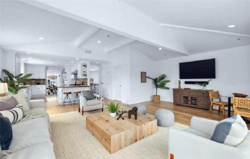 een woonkamer met een bank en een tafel bij Expansive Five Bedroom Beachside Home with Generous Living Space in Hermosa Beach