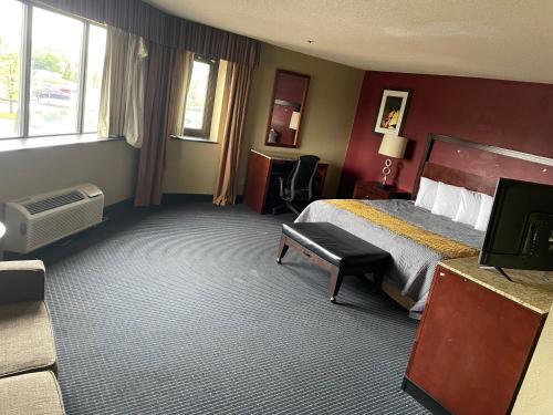 a hotel room with a bed and a television at Apm Inn & Suites in Hagerstown