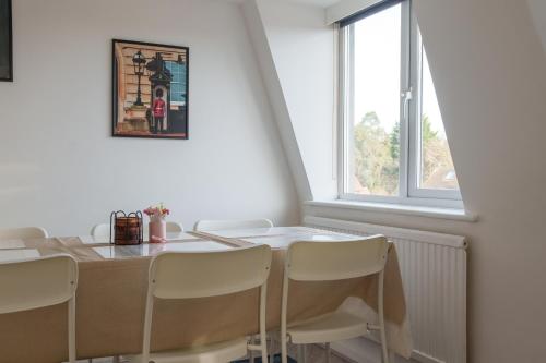 a dining room table with white chairs and a window at Oxford Modern Living - Free Parking in Oxford