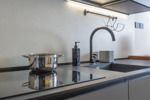 un comptoir de cuisine avec un évier et un mitigeur dans l'établissement ArtStay - Exclusive Apt Near Metro M1, AC, Parking, à Milan