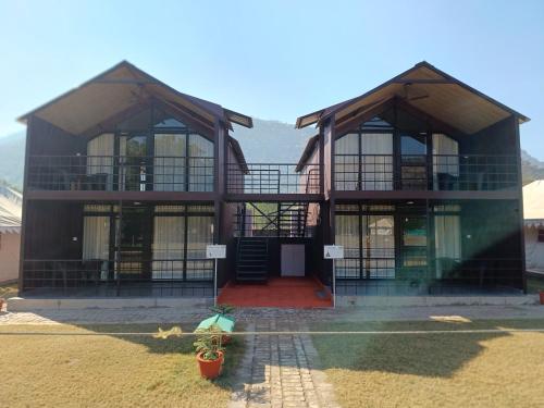 ein Haus mit großen Fenstern und einer roten Tür in der Unterkunft Shivir Aranya - Wilderness Resort in Alwar
