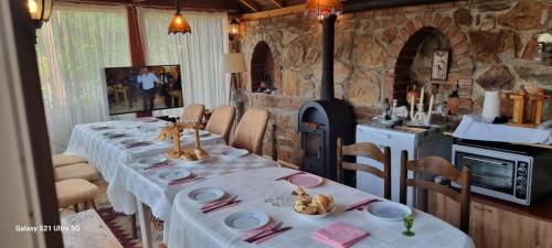 a dining room with two tables and a kitchen at Villla Gezve in Velmevci