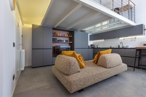 un salon avec un canapé et une cuisine dans l'établissement ArtStay - Exclusive Apt Near Metro M1, AC, Parking, à Milan