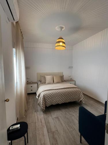 Dormitorio blanco con cama y lámpara en Casa Patio Paraíso, en Vejer de la Frontera