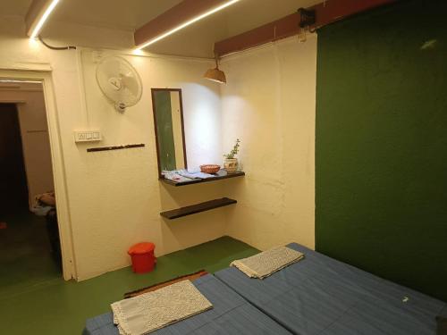 een kamer met een bed en een groene muur bij PARV Farms in Belgaum