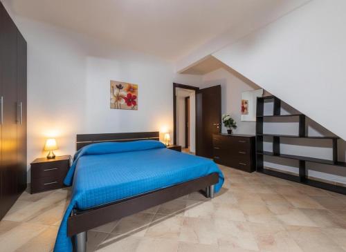 una camera con un letto blu e una scala di Villa Giulietta a Castiadas