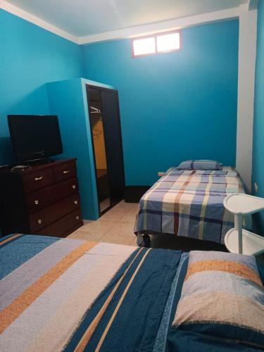 a bedroom with two beds and a television in it at Hospedaje Piquero in Puerto Baquerizo Moreno