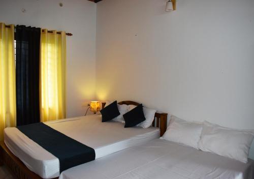 een slaapkamer met twee bedden en een raam bij MeadowView Cottage Marari in Mararikulam