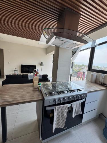 a kitchen with a stove and a living room at Mexico City, your Hub in coyoacán in Mexico City
