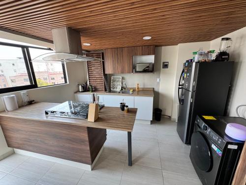 a kitchen with a table and a refrigerator at Mexico City, your Hub in coyoacán in Mexico City